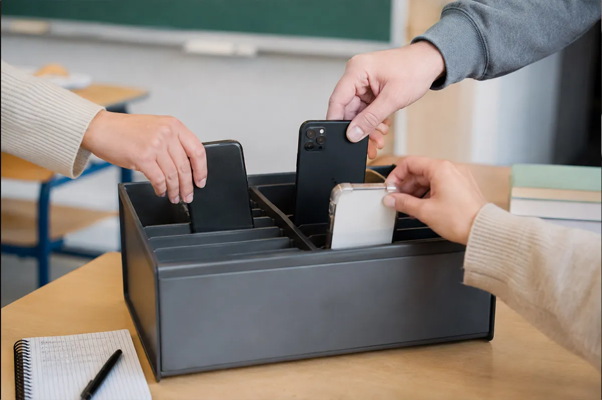 Eingesammelte Handys in einer Sammelbox — genau das vermeidet OMNI-Bags